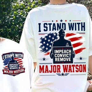 Puede incluir: Una camiseta blanca con un diseño gráfico que incluye el texto I STAND WITH, IMPEACH CONVICT REMOVE y MAJOR WATSON. El diseño presenta la silueta de una persona con uniforme, una bandera estadounidense estilizada y estrellas azules y rojas.