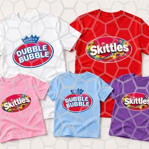 May include: A collection of five short-sleeve t-shirts in white, red, pink, light blue, and purple. The white and light blue shirts feature the Dubble Bubble logo. The red, pink, and purple shirts feature the Skittles logo on the front chest.