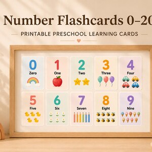 May include: A framed set of number flashcards, 0-9, with colorful illustrations. Each card displays a number, its word form, and a corresponding image, such as a rainbow for zero and an apple for one. The text "Number Flashcards 0-20" is at the top.