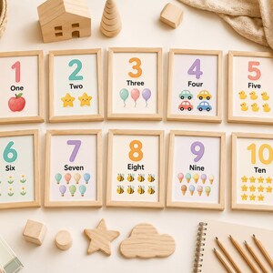 May include: A set of ten framed number cards, each with a number, its word, and corresponding illustrations. The cards feature images of an apple, stars, balloons, cars, ducks, flowers, bees, ice cream cones, and stars.