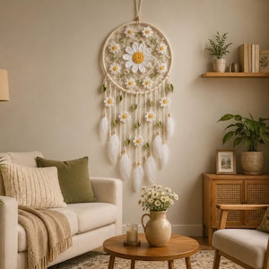 May include: A large, cream-colored dreamcatcher with daisy accents hangs on a wall. The dreamcatcher features a circular woven frame, crocheted daisies, and dangling white feathers. The room has a neutral color palette with a sofa, pillows, and wooden furniture.