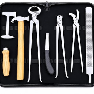 May include: A set of seven metal farrier tools arranged in a black zippered carrying case. The collection includes a hammer with a wooden handle, a hoof nipper, a hoof knife with a black handle, a rasp, and various metal pliers and tongs.
