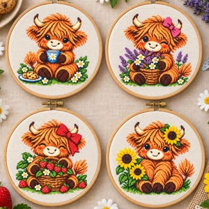 May include: Four circular embroidery hoops featuring cross-stitch designs of fluffy Highland cows. One cow holds a blue mug, one wears a pink bow with lavender, one has a red bow with strawberries, and one sits beside yellow sunflowers.