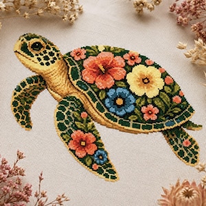 以下が含まれることがあります： 明るい色の布に施されたウミガメのクロスステッチ刺繍デザイン。黄色い頭と濃い緑色のヒレを持ち、甲羅と手足には鮮やかなオレンジ、黄色、青の花柄が刺繍されています。