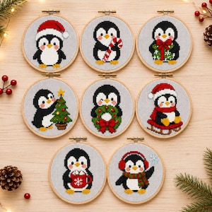 Op de afbeelding: Acht ronde borduurringen met kruissteekontwerpen van pinguïns. De pinguïns zijn afgebeeld met diverse kerstitems, waaronder een kerstmuts, zuurstok, cadeau, kerstboom, krans, slee, mok met warme chocolademelk en oorkappen.