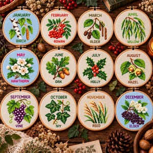 Può includere: Un set di dodici telai da ricamo circolari con disegni a punto croce di alberi e piante per ogni mese dell'anno. Ogni telaio mostra il nome del mese, un'illustrazione botanica e il nome della pianta in filo verde, rosso o viola.