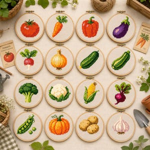 Puede incluir: Dieciséis bastidores de bordado circulares de madera que contienen patrones de punto de cruz de varias verduras, incluyendo un tomate, zanahoria, pimiento, berenjena, rábano, cebolla, pepino, calabacín, brócoli, coliflor, maíz, remolacha, guisantes, calabaza, patata y ajo.