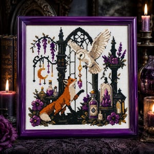 May include: A cross-stitch embroidery in a purple frame featuring a fox looking up at a flying owl holding a crystal pendant. The scene includes a gothic archway, hanging crescent moon, purple flowers, and glass potion bottles on a white fabric.