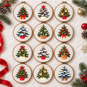 May include: Twelve circular wooden embroidery hoops containing cross-stitch patterns of Christmas trees. Each tree features unique decorations including red bows, gold stars, ornaments, snow, and dried orange slices on a white fabric background.