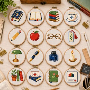 May include: Sixteen circular wooden embroidery hoops featuring cross-stitch designs of academic and literary items, including a blue book, an open book, a stack of books, a teacup, a pencil, an apple, glasses, a bookmark, a lamp, a pen, an inkwell, a candle, a plant, a letter, a journal, and a document.