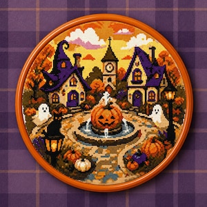 May include: A circular cross-stitch embroidery featuring a Halloween scene with two purple-roofed houses, a central pumpkin fountain, a black cat, and two white ghosts. The design is framed in a round orange hoop against a purple plaid background.