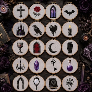 May include: A collection of twenty circular wooden embroidery hoops, each containing a unique cross-stitch design on white fabric. The motifs include a cross, rose, gothic arch, bat, castle, raven, heart, candle, chalice, door, moon, coffin, chandelier, crystal, key, potion, gate, mirror, book, and spiderweb.