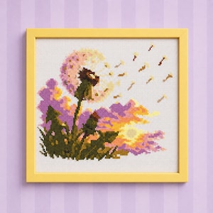 Könnte beinhalten: Eine Kreuzstichstickerei in einem gelben Rahmen, die einen Löwenzahn mit im Wind wehenden Samen vor einem Sonnenuntergangshintergrund aus violetten, orangen und gelben Wolken zeigt. Die grünen Stängel und Blätter befinden sich an der Basis.