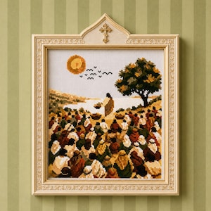 May include: A framed cross-stitch embroidery depicting a large crowd gathered on a hillside near a body of water, with a central figure standing before a tree. The ornate, light-colored frame features a small gold cross at the top center.