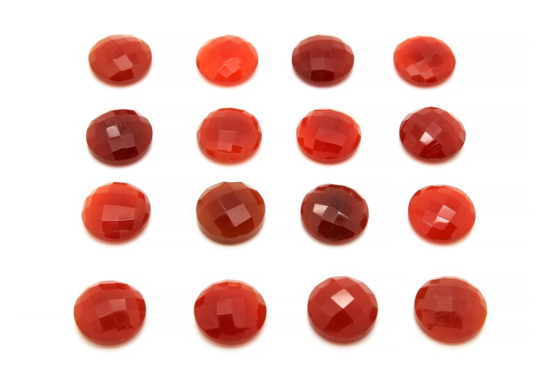 May include: Fifteen round, red carnelian gemstones with a faceted finish. The stones are arranged in a grid pattern on a white background.