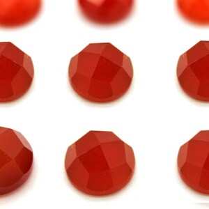 May include: Ten round, faceted carnelian gemstones in various shades of red.