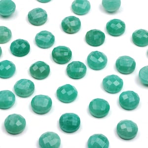 Peut inclure: Une collection de 30 pierres pr&eacute;cieuses rondes, facett&eacute;es et vertes. Les pierres sont lisses et polies, avec une teinte vert clair.