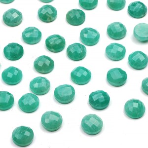 Peut inclure: Une collection de 30 pierres pr&eacute;cieuses rondes, facett&eacute;es et vertes. Les pierres sont dispos&eacute;es de mani&egrave;re dispers&eacute;e sur un fond blanc.