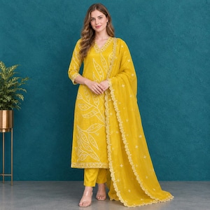 Könnte beinhalten: Ein senfgelbes dreiteiliges Set bestehend aus einem langärmeligen, geraden Kurta mit weißer Blattstickerei, einer passenden geraden Hose und einem transparenten, leichten Dupatta mit einer gewellten, bestickten Bordüre.