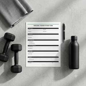 May include: A white Personal Trainer Intake Form document with black text and lines, accompanied by two black dumbbells, a black pen, and a grey waffle-textured towel. The form includes sections for client profile, fitness goals, and health screening.