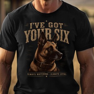 Könnte beinhalten: Ein schwarzes Kurzarm-T-Shirt mit einer Grafik eines braunen Deutschen Schäferhundes mit Halsband. Der Text I'VE GOT YOUR SIX steht oben und ALWAYS WATCHING ALWAYS LOYAL unten in einer abgenutzten beigen Schrift mit kleinen Sternen.