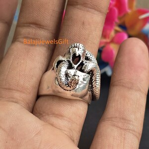 May include: A silver-toned ring featuring a detailed, coiled snake design with textured scales and a smooth band. The metal surface has an oxidised finish to highlight the intricate snake pattern. The text BalajiJewelsGift is visible.