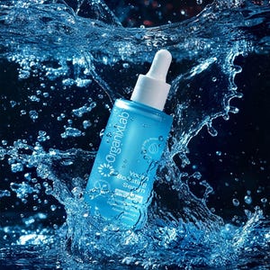 May include: A blue OrganixLab Youth Boosting Serum bottle with a white dropper is surrounded by splashing water. The bottle has white text and a flower logo. The serum contains ingredients like Hyaluronic Acid and Retinol.