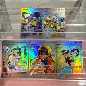 May include: Five holographic Pokémon trading cards featuring Trainer characters Iono, Lisia's Appeal, Carmine, and Perrin. Each card displays colorful anime-style illustrations, text, and game mechanics, arranged in two rows within a clear display stand.