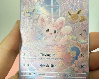 Könnte beinhalten: Eine holografische Minccino-Sammelkarte mit 60 KP, die den Charakter mit einem Staubwedel in einem pastellfarbenen Raum mit anderen Kreaturen zeigt. Der Kartentext enthält Tidying Up, Gentle Slap und Mythical Garden Series 4/5.