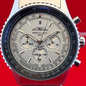 Relógio masculino vintage Breitling 1884 Navitimer Chrono Quartz com mostrador branco, caixa e pulseira em aço inoxidável, bisel giratório, subsegundos e data.