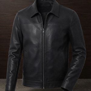 May include: A black leather jacket featuring a classic point collar, a full-length front metal zipper closure, long sleeves with buttoned cuffs, and horizontal seam detailing across the chest. The jacket has a smooth finish and two side pockets.