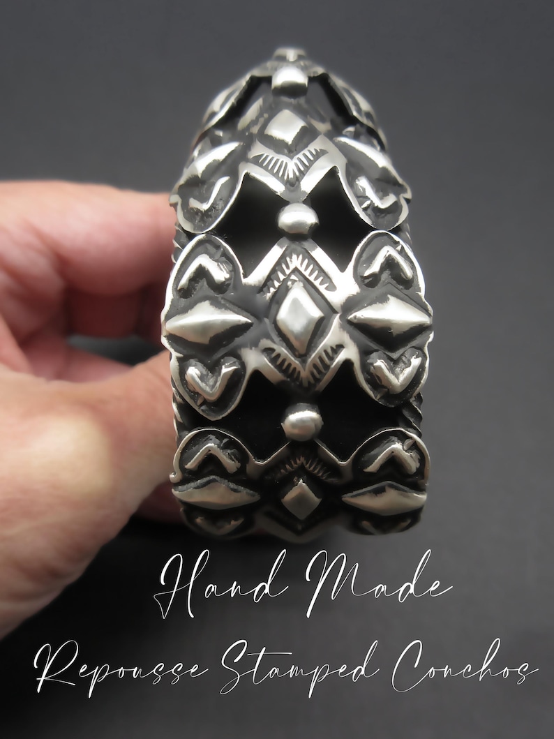 May include: A silver bracelet with a hand-made repousse stamped concho design. The bracelet is made of silver and has a geometric pattern.
