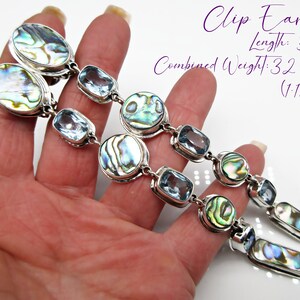 May include: A pair of clip-on earrings featuring abalone shell and blue topaz stones. The earrings are 5 1/2 inches long and weigh 32 grains (1/12 oz).