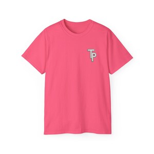 May include: A short-sleeved, hot pink t-shirt with a small, silver-colored "TP" logo on the left chest. The shirt is made of a soft material and is suitable for casual wear. The design is simple and modern.