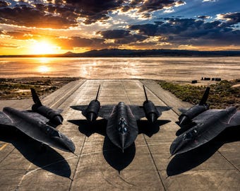 Könnte beinhalten: Drei schwarze SR-71 Blackbird Aufklärungsflugzeuge, die in einer Reihe auf einer Betonpiste stehen. Die Jets haben lange, schlanke Rümpfe, Deltaflügel und doppelte Triebwerksgondeln. Die Szene ist vor einem hellen Sonnenuntergang dargestellt.