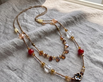 Collar de cuentas de varias hebras: Cadena estilo boho en capas con dijes de hojas y monedas.