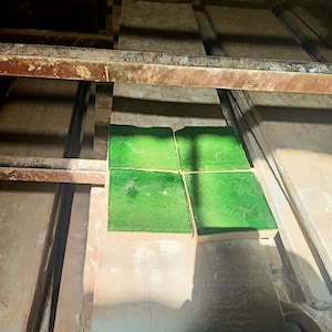 Puede incluir: Cuatro azulejos de cerámica cuadrados con un acabado esmaltado en verde vibrante dispuestos en una cuadrícula de dos por dos. Los azulejos presentan una superficie lisa y brillante con sutiles variaciones en la intensidad del color.