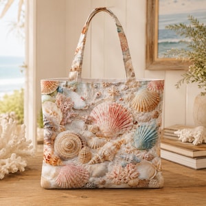 May include: A tote bag featuring a detailed all-over print of various seashells, coral fragments, and sandy textures in shades of white, beige, pink, and soft blue. The bag includes two matching fabric handles and a rectangular structure.