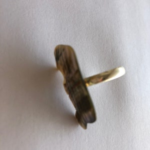 May include: A gold ring featuring a detailed, textured butterfly design.