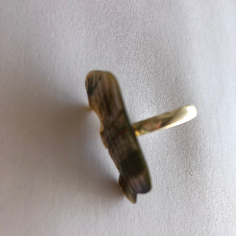 May include: A gold ring featuring a detailed, textured butterfly design.