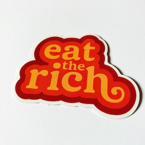 May include: A red and orange sticker with the text "eat the rich" in a retro font.