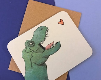 May include: A white card with a green dinosaur illustration and a red heart. The dinosaur is looking to the right and has its mouth open. The card has a brown envelope.