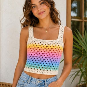 May include: A rainbow-striped crochet crop top with a square neckline and cream-colored trim. The top transitions from yellow to pink, blue, and green. The model is wearing blue denim jeans.