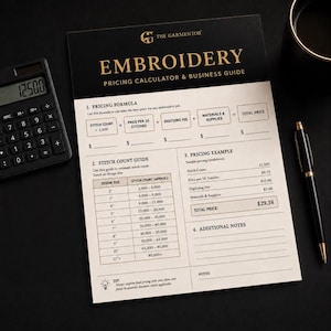 Puede incluir: Una guía de cálculo de precios y negocios de bordado en negro y dorado. La guía incluye fórmulas de precios, guías de conteo de puntadas y un ejemplo de precios. Una calculadora y un bolígrafo también están en la superficie negra.