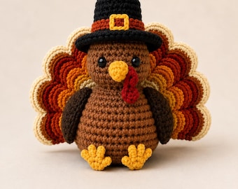 May include: A crocheted turkey figurine featuring a brown body, yellow beak, and red wattle. The turkey wears a black top hat with a brown band and a yellow buckle. Its tail feathers are layered in shades of cream, orange, red, and dark brown.