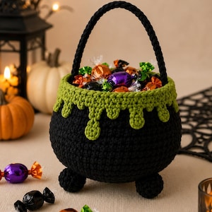 May include: A black crocheted cauldron basket with a braided handle and three small feet. The top rim features a lime green drip pattern resembling bubbling liquid. The basket is filled with assorted colorful wrapped candies.