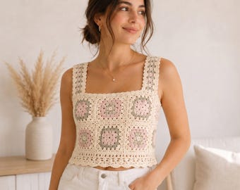 May include: A sleeveless crochet top featuring a square neckline and wide straps. The garment is constructed from multiple granny square motifs in a color palette of cream, soft pink, and sage green, finished with a scalloped edge at the hem.