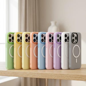 May include: A selection of brightly coloured phone cases in green, yellow, orange, blue, pink, purple, white, and grey. Each case features a circular design. The cases are arranged on a wooden surface.