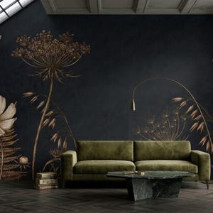 May include: A dark charcoal wall mural featuring large, detailed botanical illustrations of ferns, wildflowers, and grasses in shades of bronze and gold. The mural serves as a backdrop for an olive green sofa and a dark green marble coffee table.