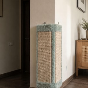 May include: A corner cat scratching post, featuring a central panel of woven rope and a soft, pale green trim. The rectangular design is made from durable materials. This cat scratcher provides a stylish and practical solution for feline scratching needs.